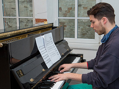 Ein junger Mann spielt Klavier.