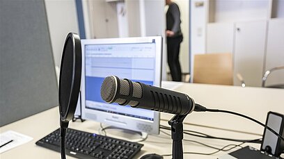 Ein Computer-Arbeitsplatz mit einem Mikrofon für eine Aufnahme