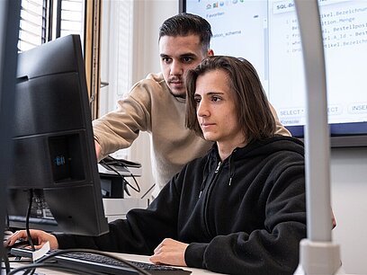 Zwei Auszubildende arbeiten am Computer.