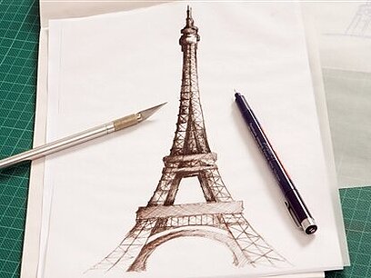 Eine Zeichnung vom Eiffelturm, neben der zwei Stifte liegen.
