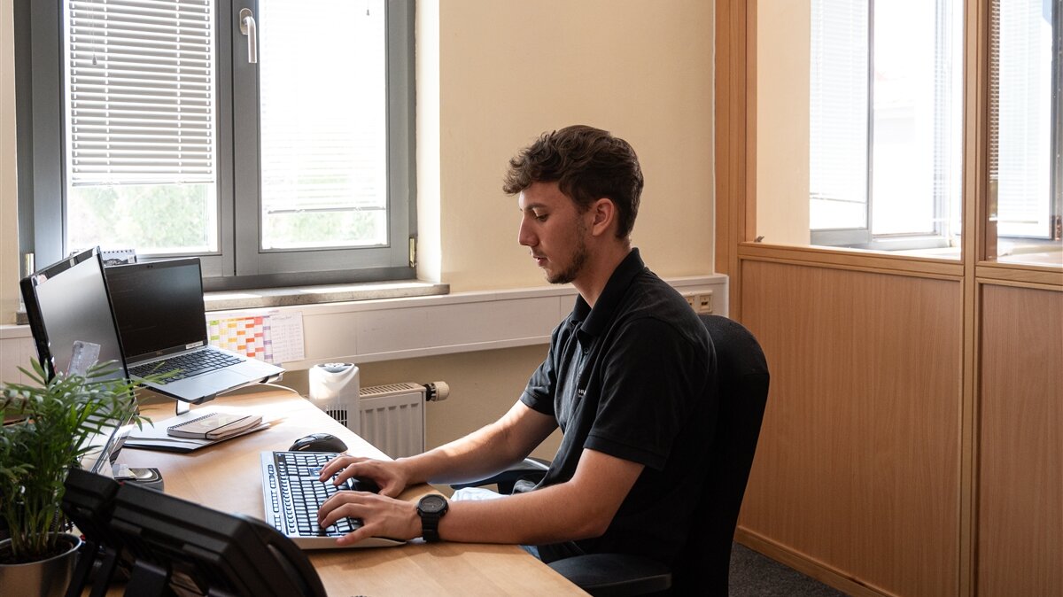 Ein junger Mann arbeitet am Computer.