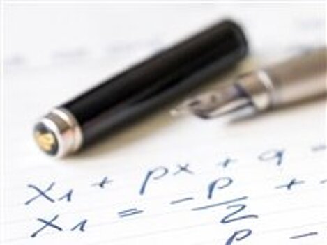 Ein Füller und eine Füllerkappe liegen auf einem Blatt mit mathematischen Gleichungen.