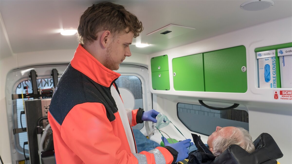 Ein Rettungssanitäter versorgt einen Patienten im Krankenwagen.