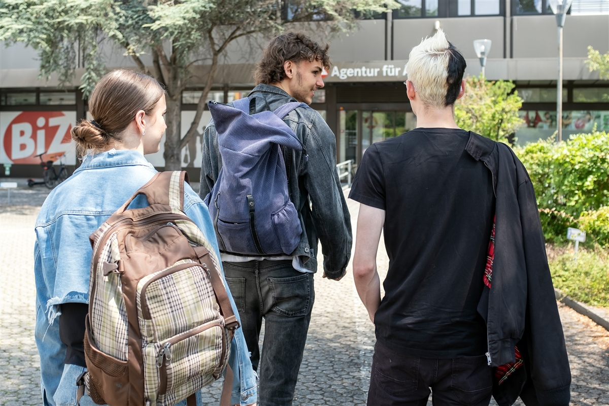 Zwei männliche und eine weibliche Jugendliche auf dem Weg in das Berufsinformationszentrum. und