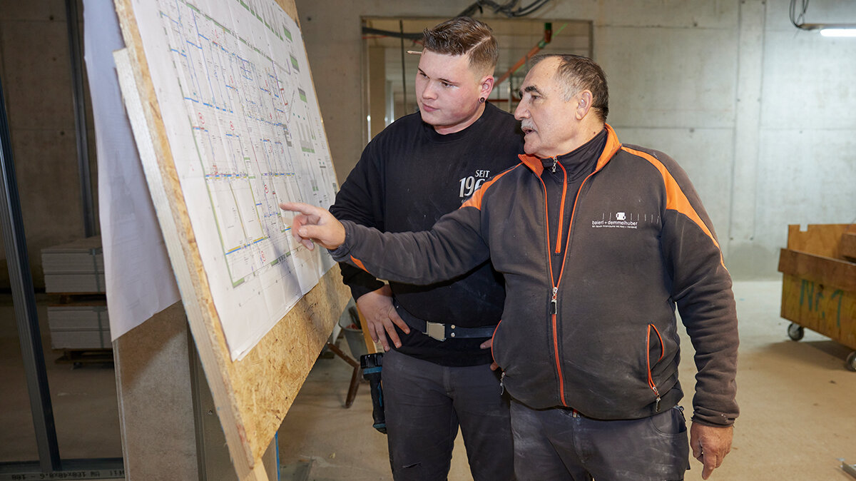 Benjamin und der Obermonteur besprechen den Bauplan.