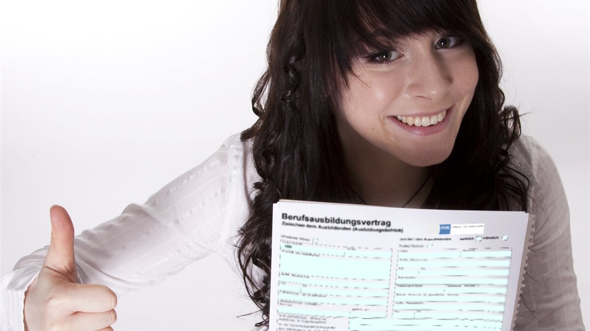 Eine junge Frau freut sich darüber, dass sie ihren Ausbildungsvertrag erhalten hat.