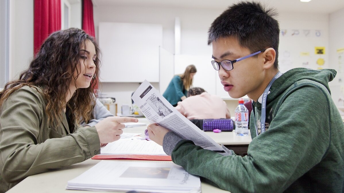 Ein Schüler und eine Schülerin sitzen im Klassenzimmer.