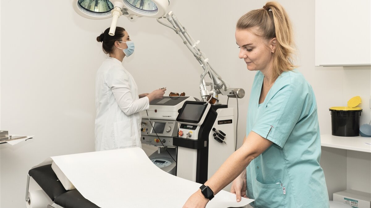 Zwei junge Frauen bereiten einen Untersuchungsraum vor.