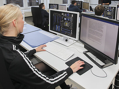 Eine junge Frau arbeitet an einem Computer.