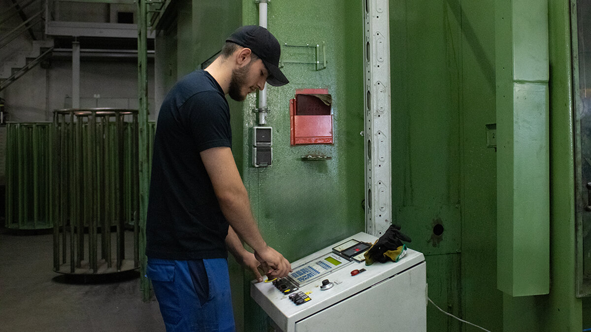 Altin schaltet eine Drahtziehmaschine in einer Werkhalle ein.