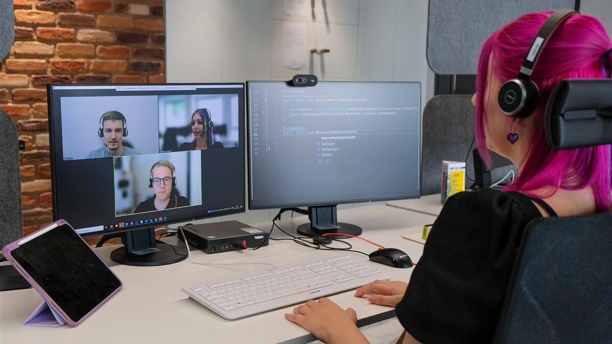 Johanna nimmt am Computer mit Headset an einem Online-Team-Meeting teil..