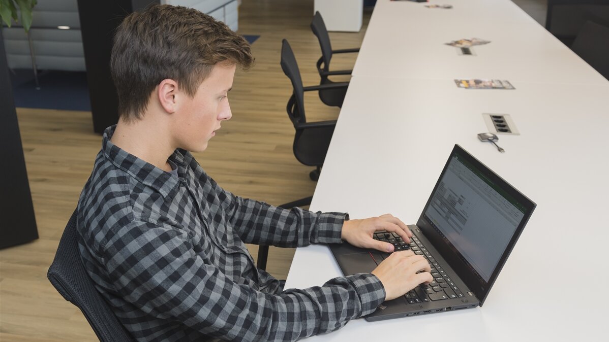 Ein Jugendlicher arbeitet an einem Laptop.