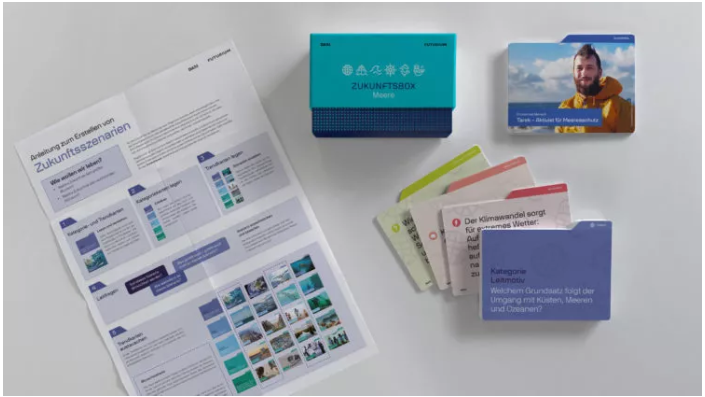  Der Inhalt der Zukunftsbox Meere enthält mehrere Kärtchen, ein Infoblatt und eine kleine Schachtel.