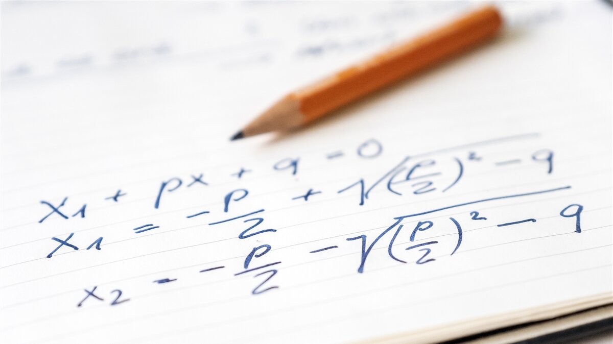 Mathematische Formeln auf einem Blatt Papier und einem Bleistift im Hintergrund.