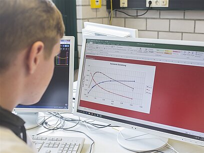Ein junger Mann arbeitet mit einem Koordinatensystem in einem Programm am Computer.