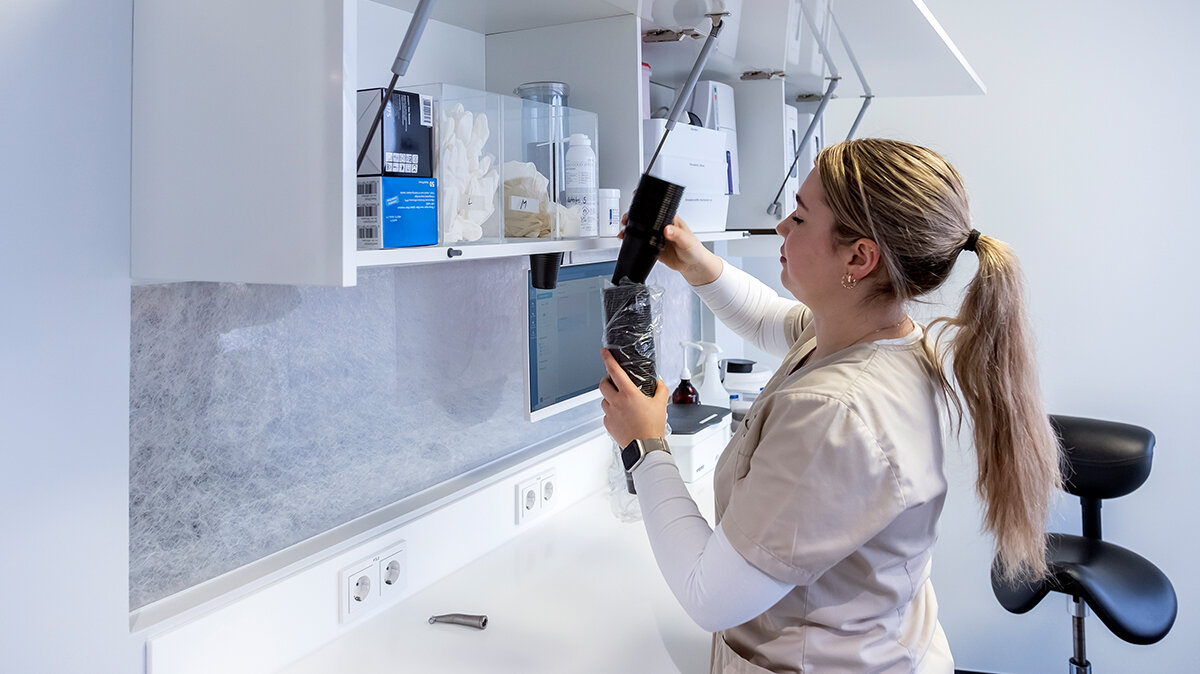 Karolin füllt die Schränke im Behandlungszimmer mit Material auf.