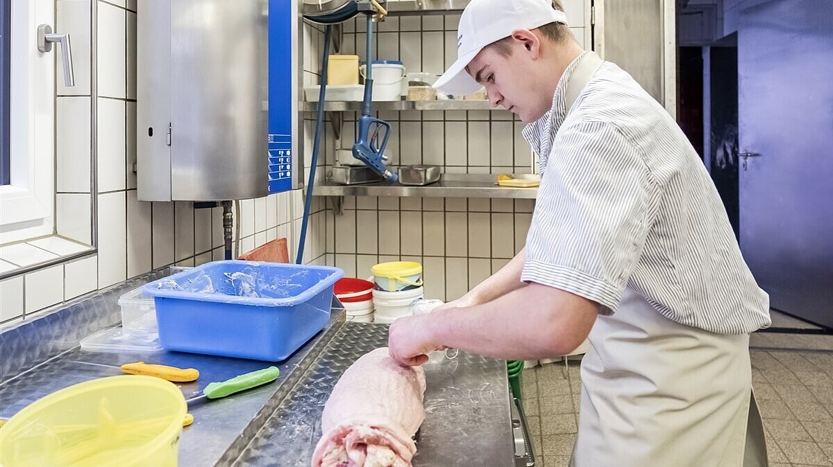 Stefan fixiert den Rollbraten mit Bindfaden.