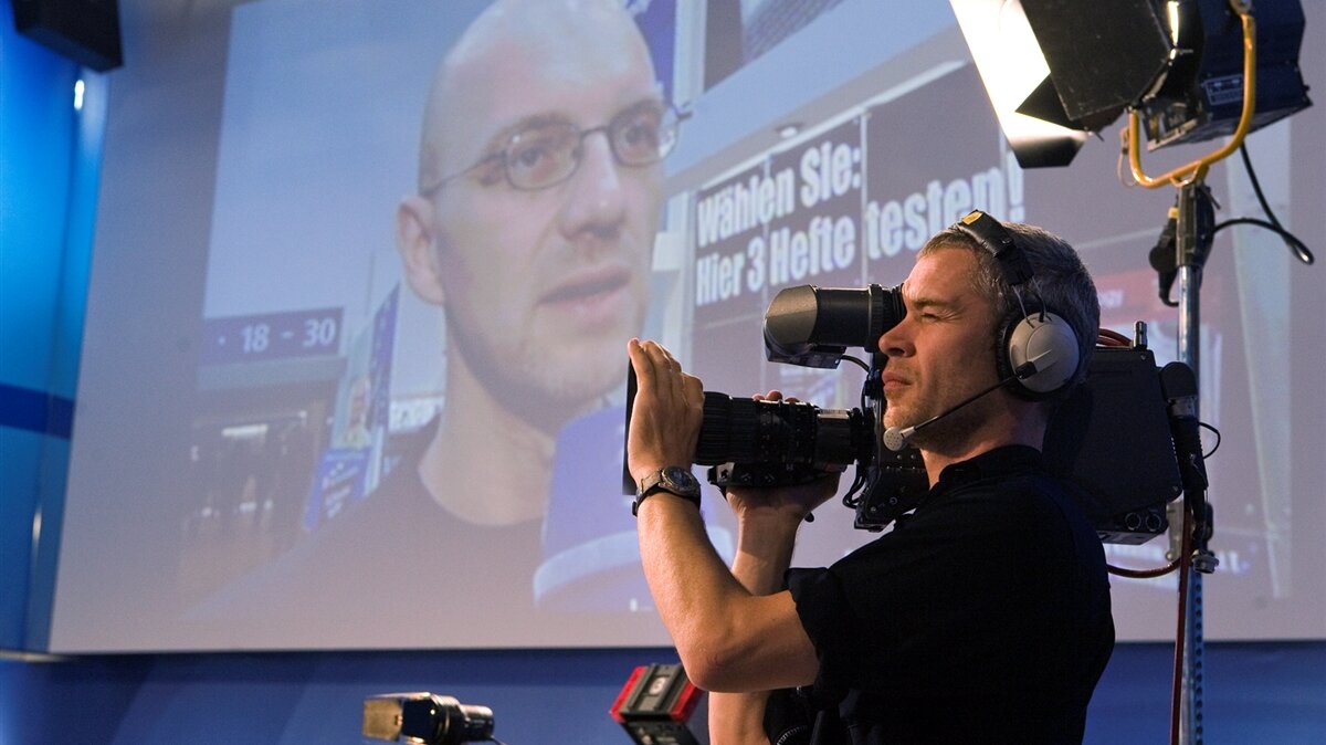 Ein Kameramann filmt eine Interviewszene.