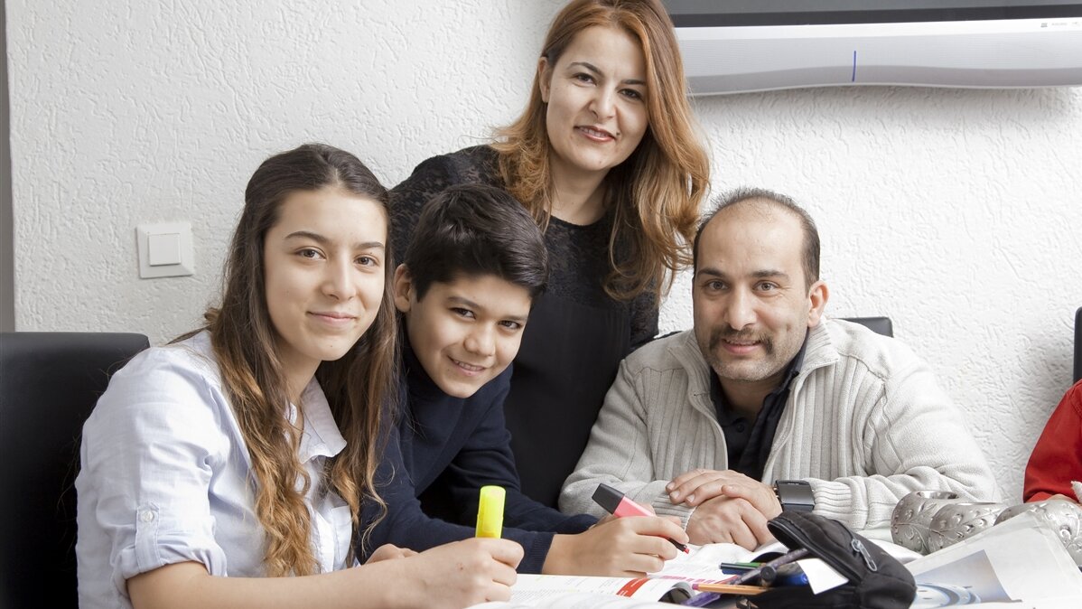 Eine multikulturelle Familie lächelt in die Kamera