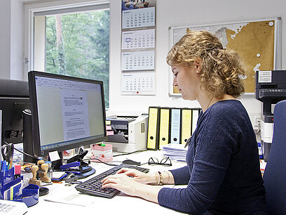 Eine junge Frau arbeitet am Computer.