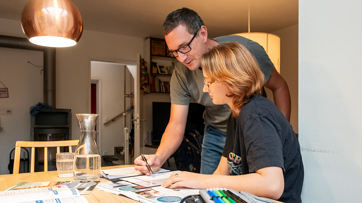 Ein Vater hilft seiner Tochter bei den Hausaufgaben.