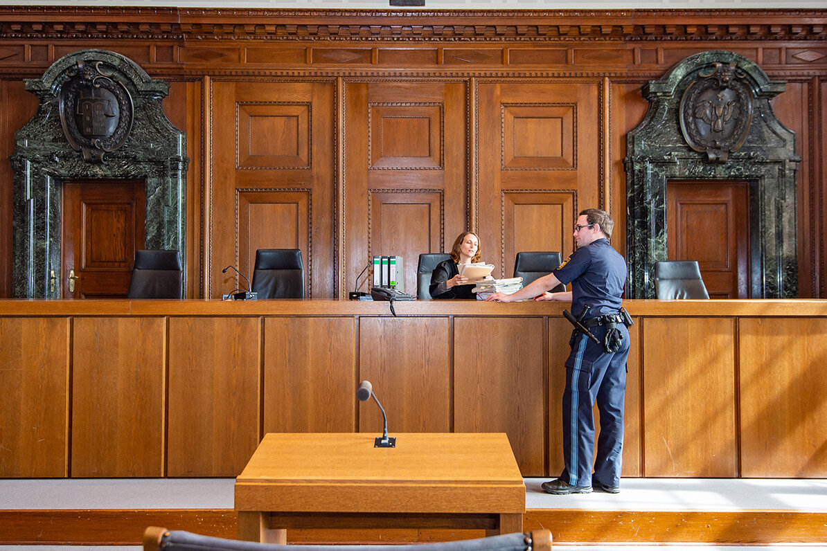 Eine Richterin spricht im Gerichtssaal mit einem Mann.