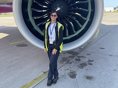 Letizia steht vor dem Propeller eines Flugzeugs.