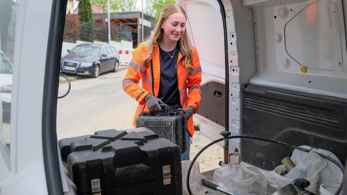 Anna belädt einen Transporter mit Geräten.