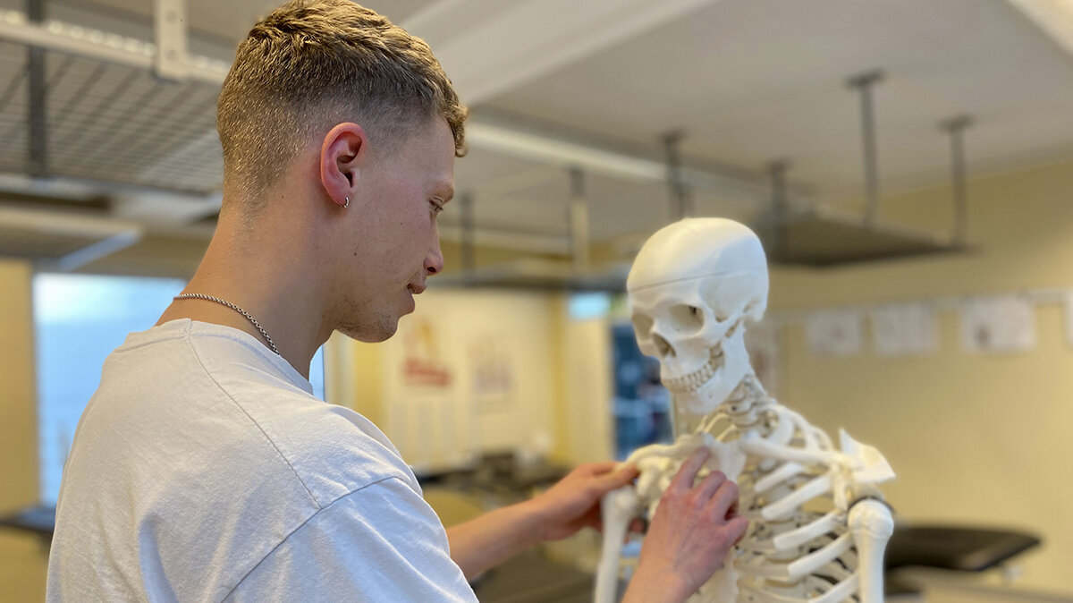 Simon bestimmt die Knochen am Skelett-Modell eines menschlichen Körpers.