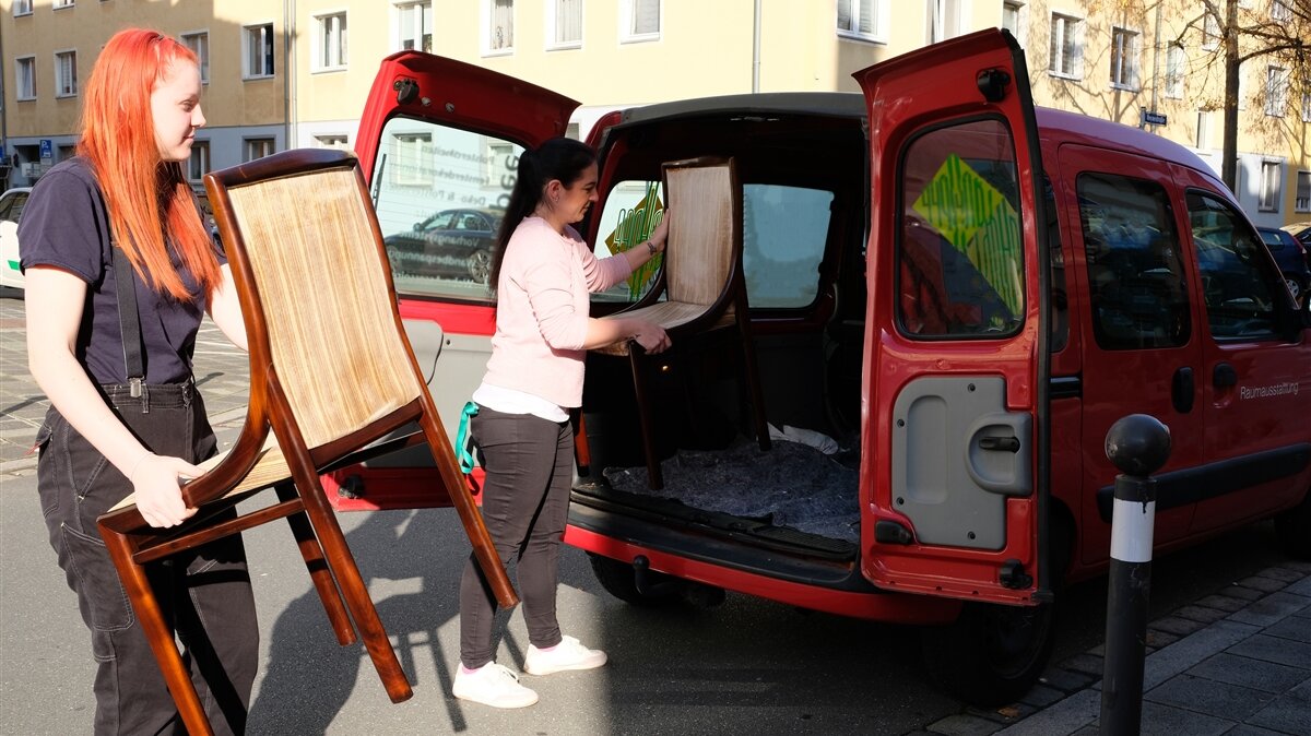 Corvina und ihre Ausbilderin laden die abgeholten Stühle aus dem Auto.