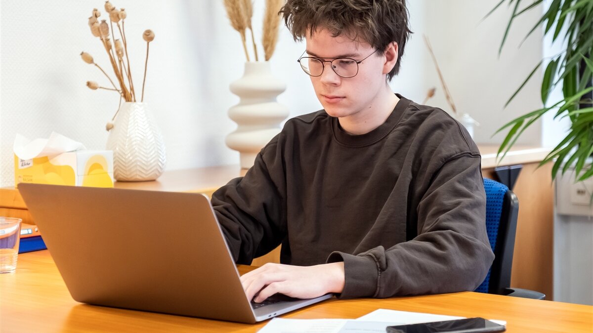 Ein junger Mann arbeitet am Laptop.
