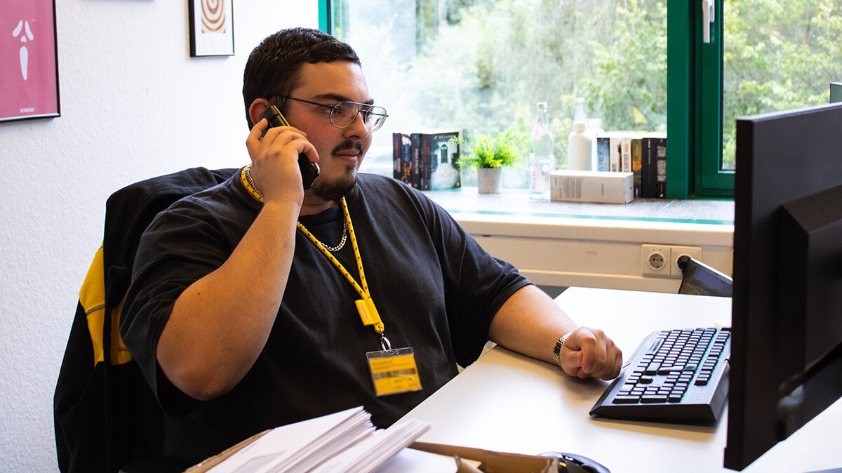 Michael telefoniert im Büro mit einem Kollegen.