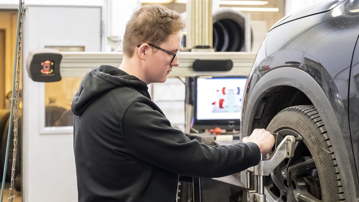 Tobias bringt einen Sensor an die Felge eines Autoreifens an.