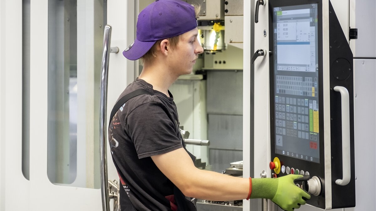 Luca stellt das passende Programm an der CNC-Fräsmaschine ein.