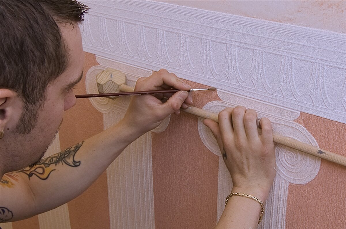Ein Maler verziert eine Wand.