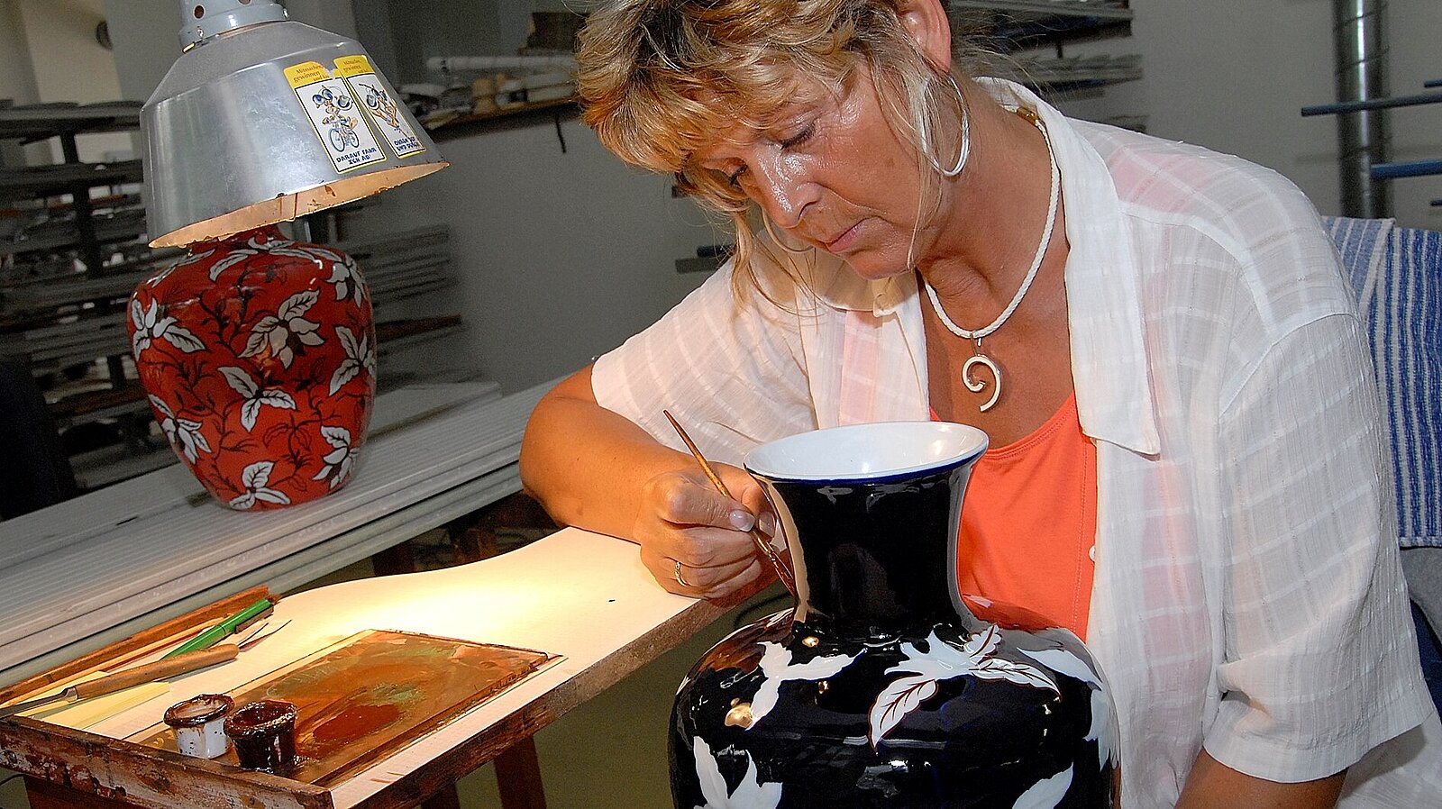 Eine Frau gestaltet eine Vase.
