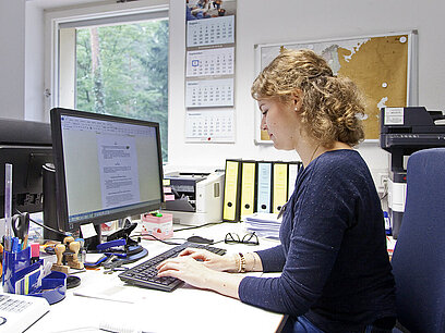 Eine junge Frau arbeitet am Computer.