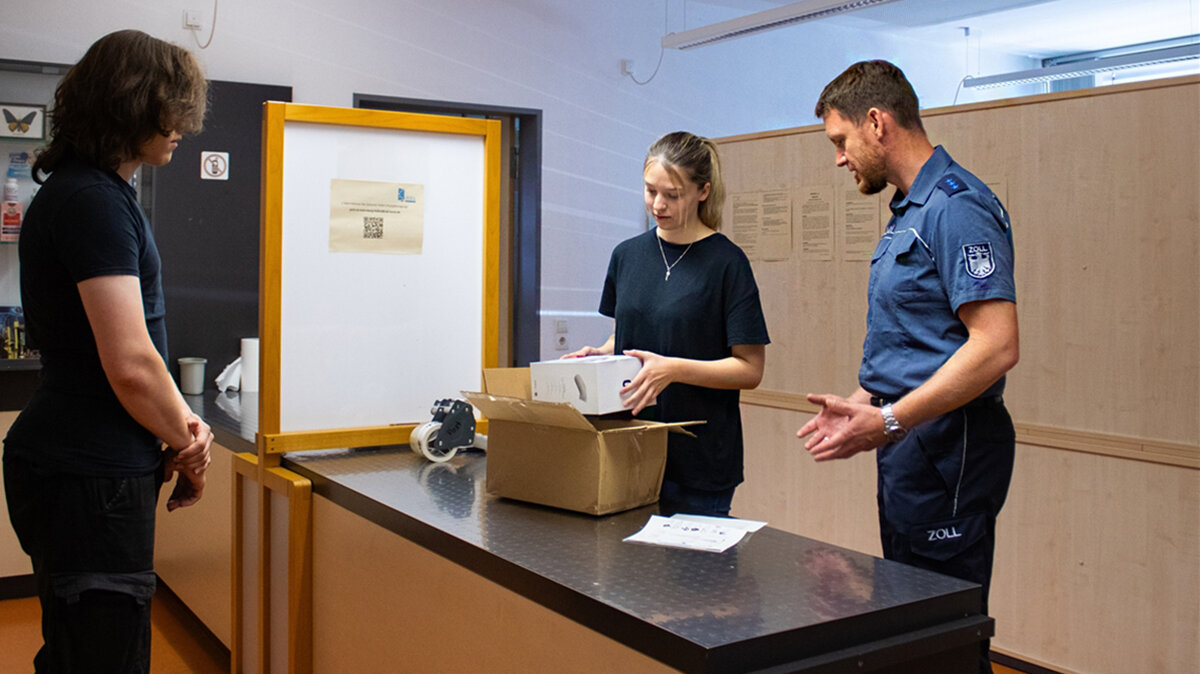Alicia und ihr Ausbilder beschauen ein Paket und prüfen die Dokumente.