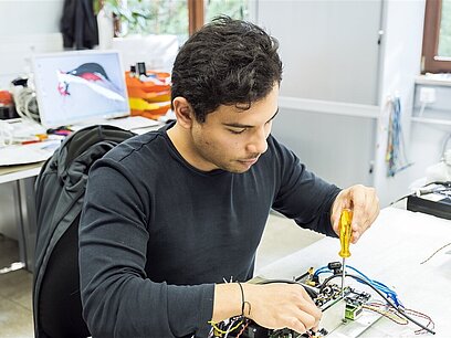 Ein Mann repariert ein Elektronisches Gerät.