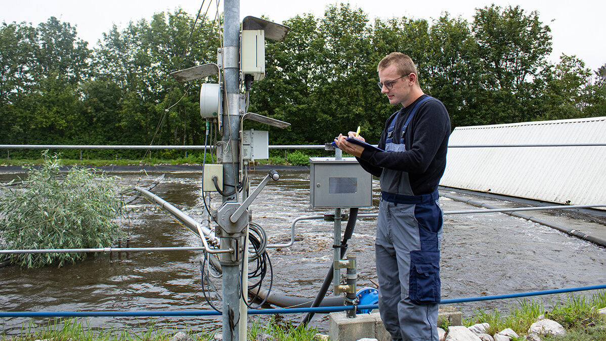 Luis notiert sich auf einem Klemmbrett die Strom- und Wasserzählerstände.
