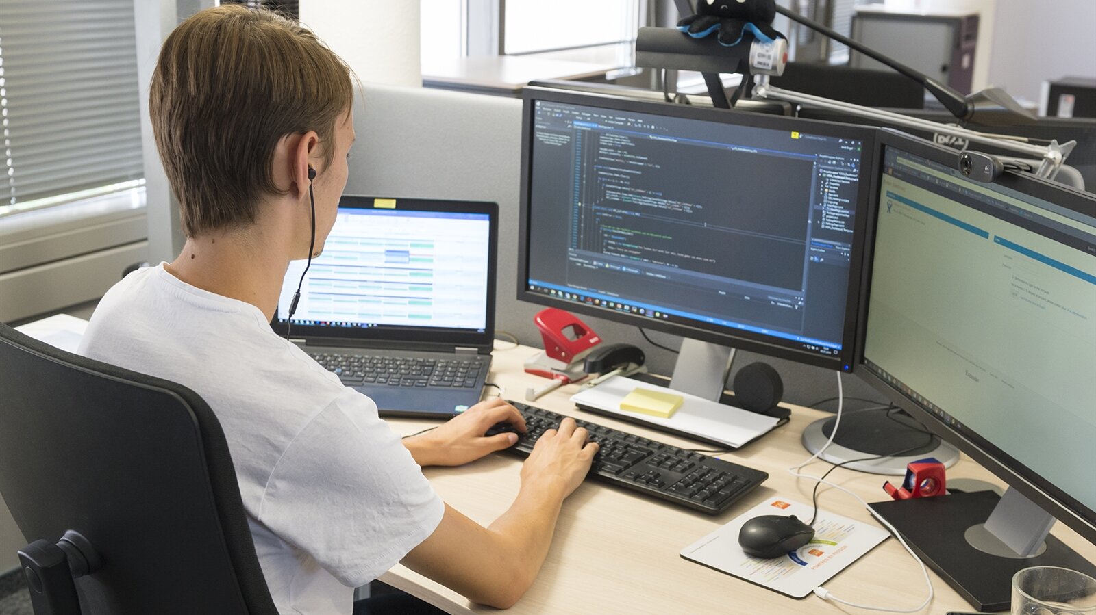 Janik programmiert am Computer eine Software.