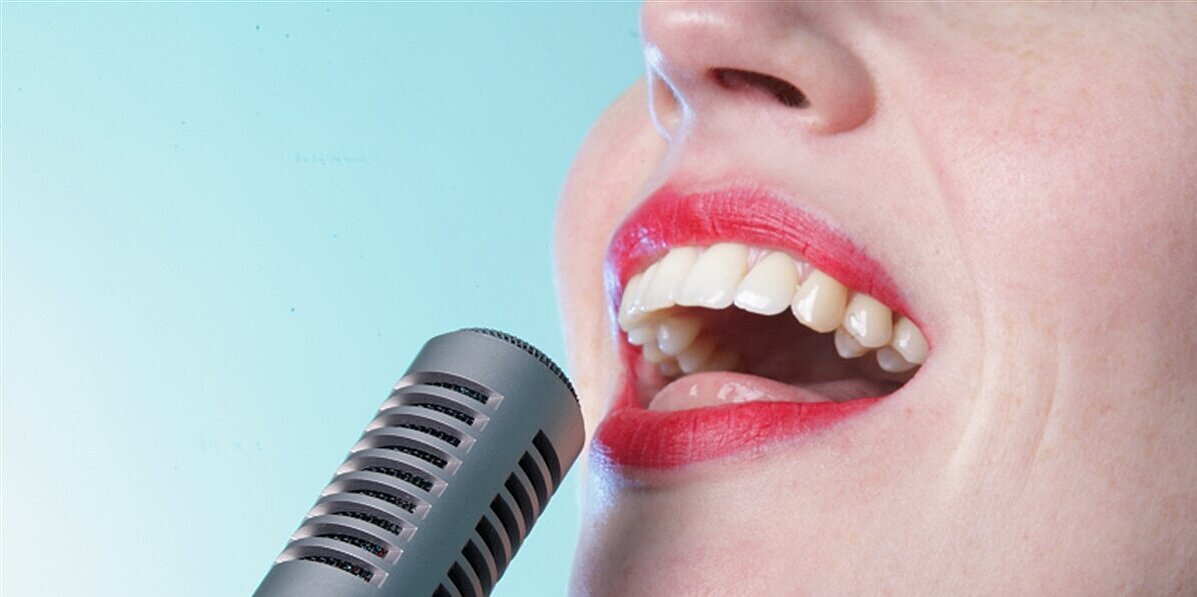Eine Frau singt ins Mikrofon.