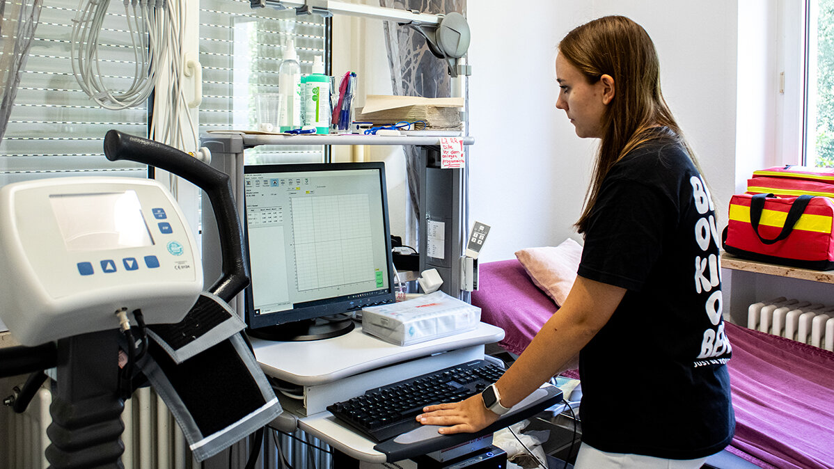 Yasmina gibt Patientendaten in einen Computer ein.