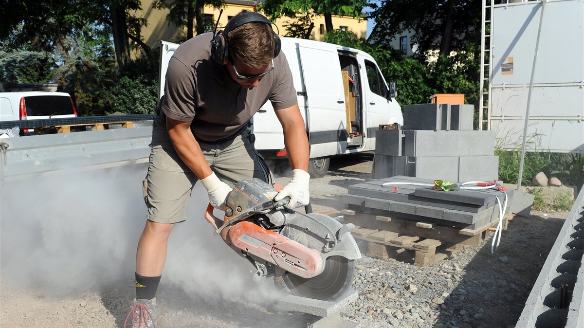 Ein Mann bearbeitet ein Stück Beton mit einer Betonsäge.