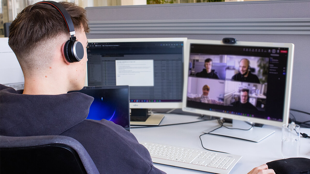 Paul sitzt am Computer und nimmt an einer Videokonferenz teil.