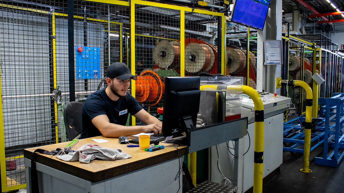Altin schaut sich am Computer Kundenaufträge an.