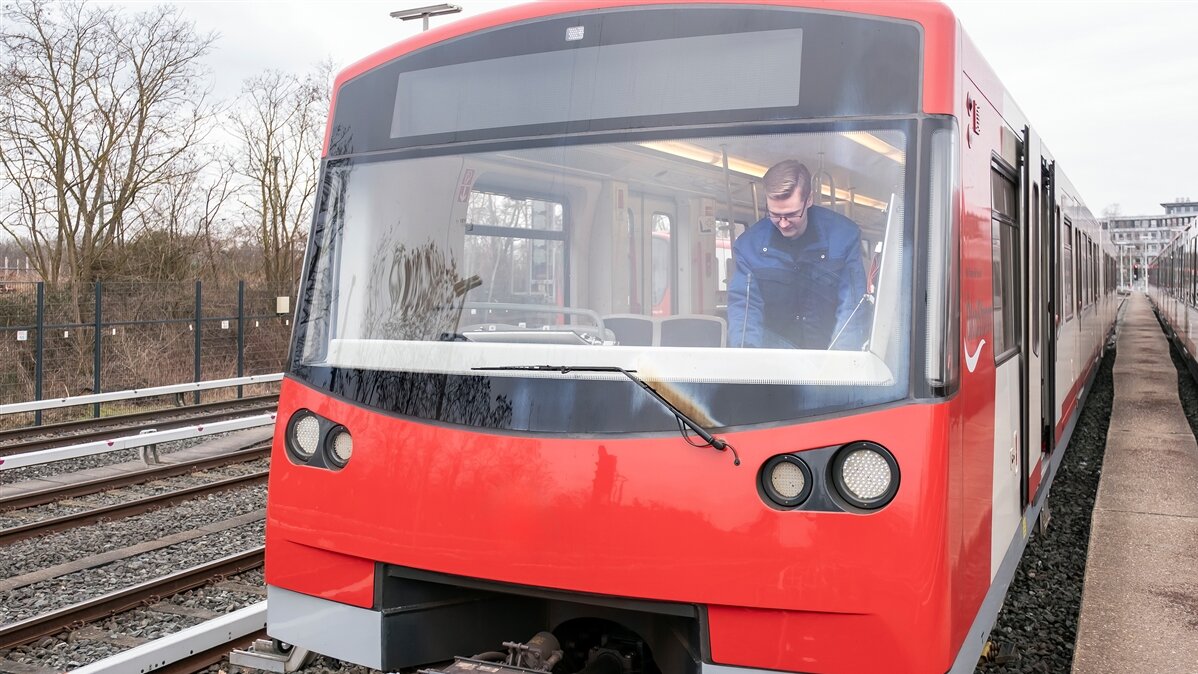 Drei Männer stehen mit ihren Fahrrädern draußen auf einem gepflastertem Weg.