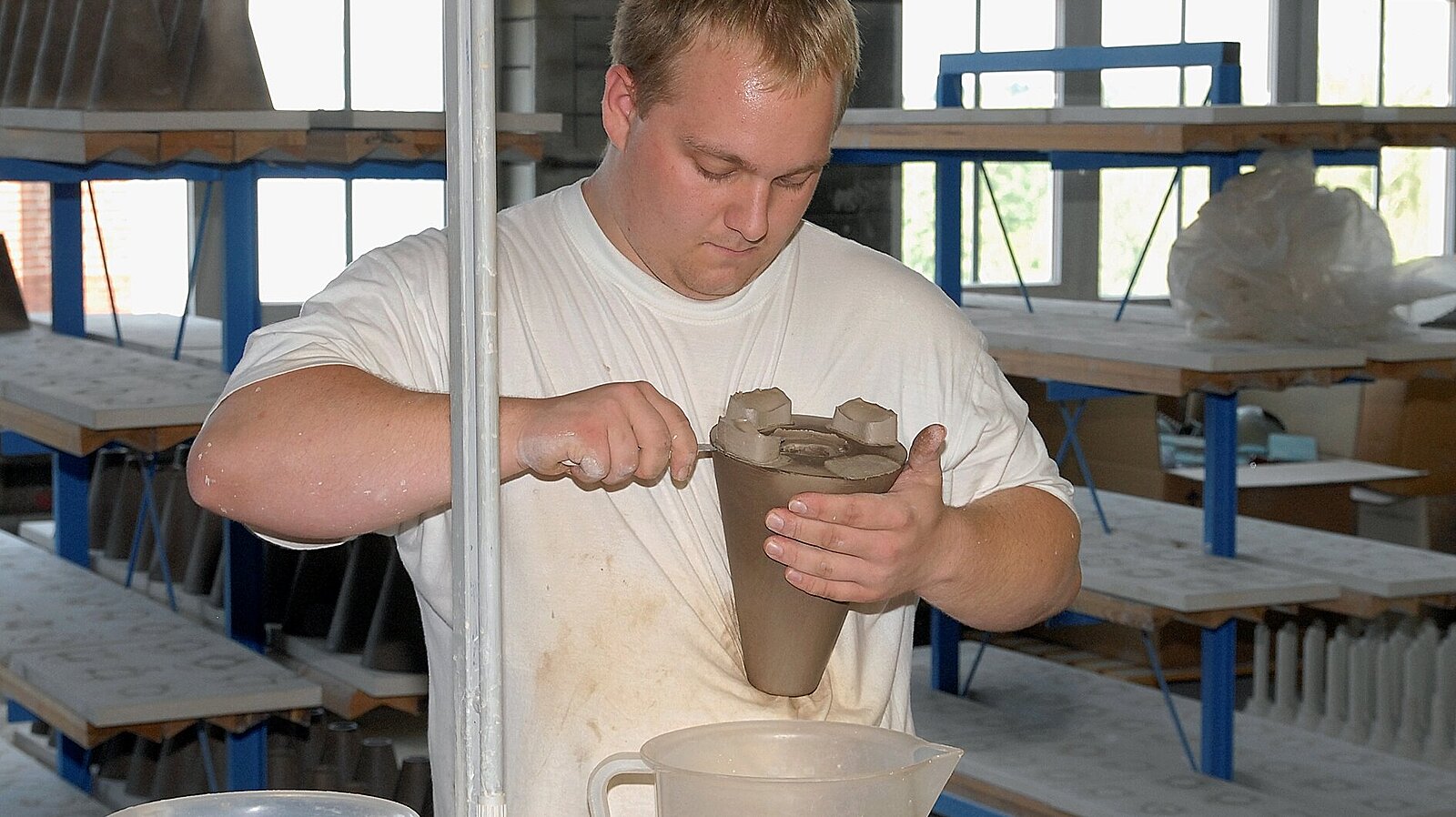 Ein Mann arbeitet mit einem Keramikprodukt.