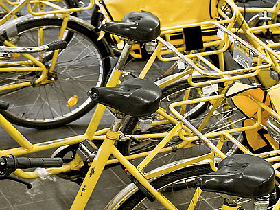 Gelb-schwarze Postfahrräder stehen nebeneinander.