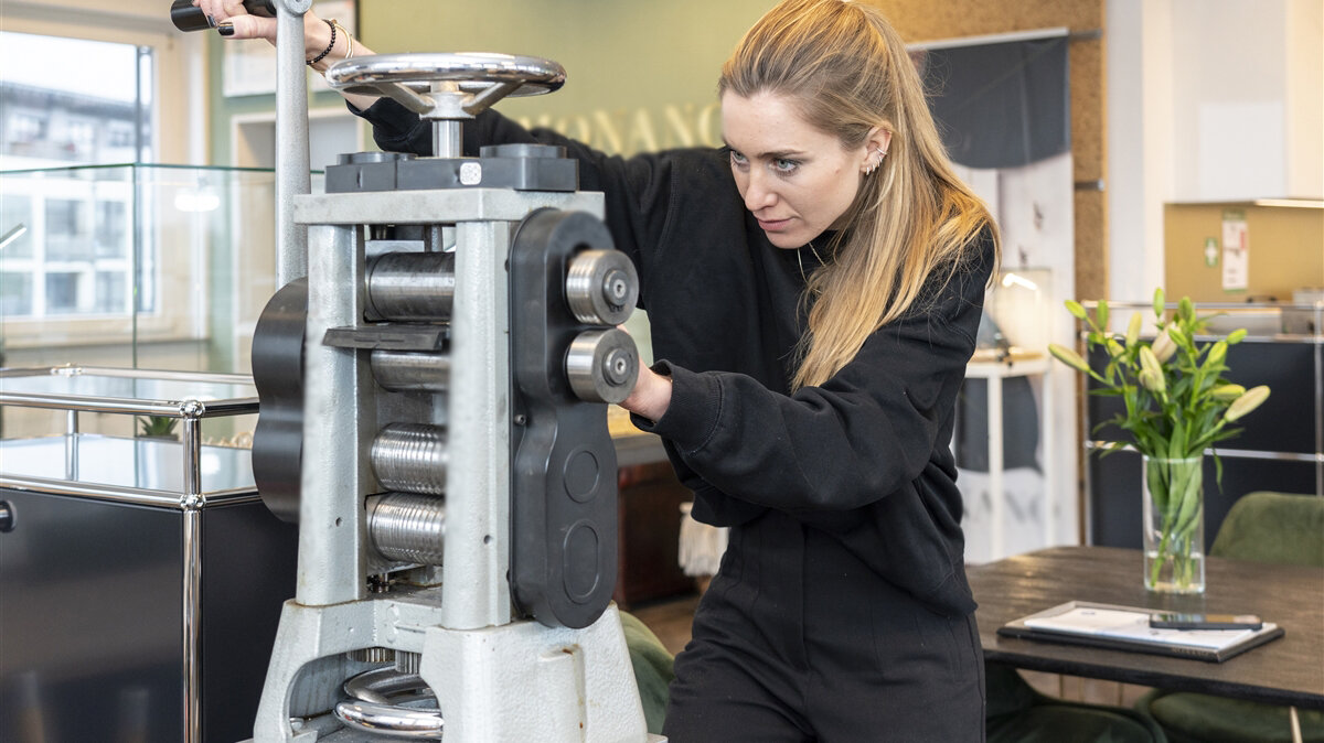 Eine junge Frau benutzt ein Messgerät für metallische Zylinder.